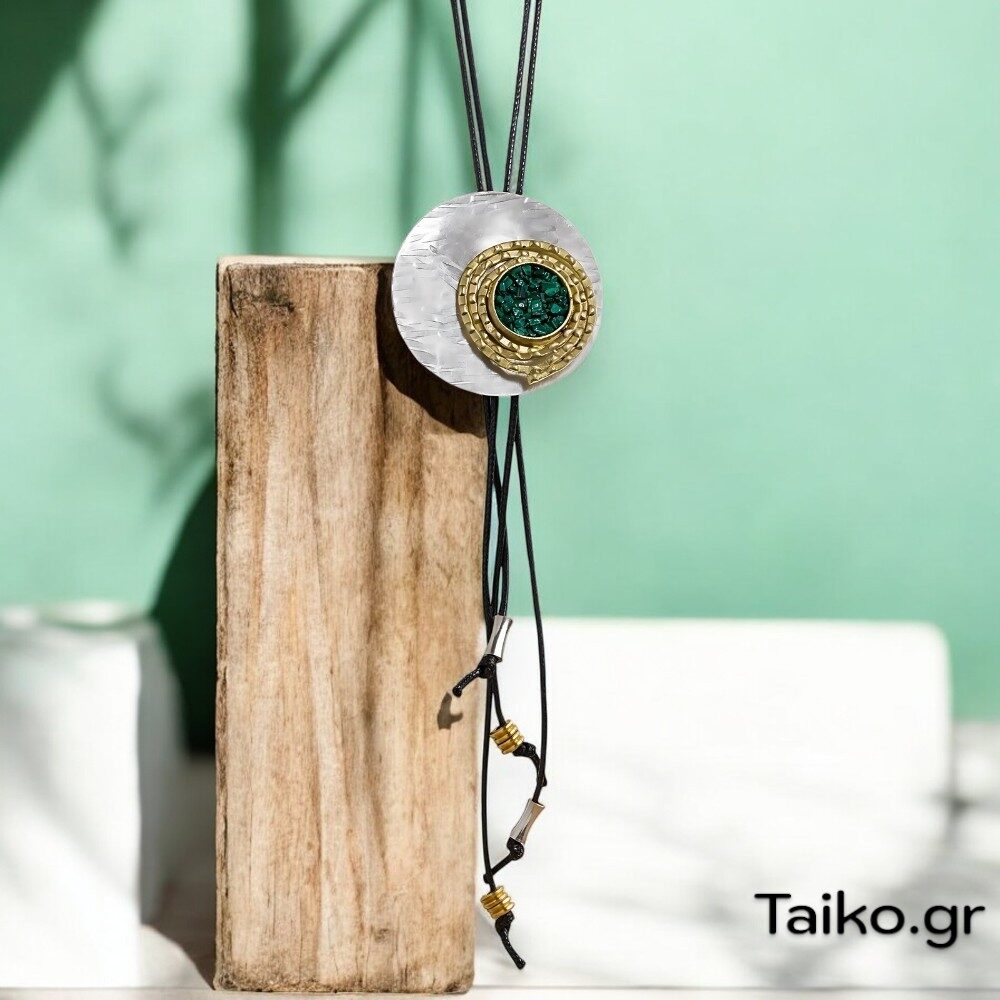 Χειροποίητο κολιέ με στρογγυλό στοιχείο από επαργυρωμένο σφυρήλατο ορείχαλκο και συνδυασμένο με πράσινες πέτρες (μαλαχίτη) σε επιχρυσωμένη, ανάγλυφη σπείρα (μακρύ με ρυθμιζόμενο κορδόνι) 